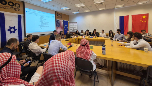 TAU students and faculty sitting around a square table at a negotiation simulation lesson