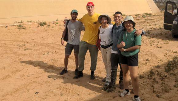 four students and their professor in the field standing together